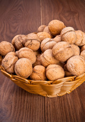 walnuts in a wicker basket on a wooden background