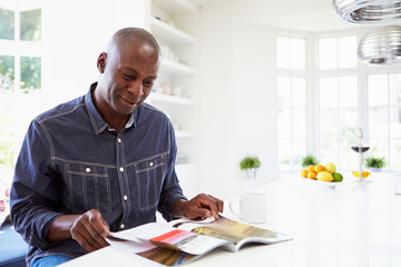 African American Man Reading Magazine At Home