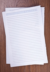 sheets of paper on a wooden background