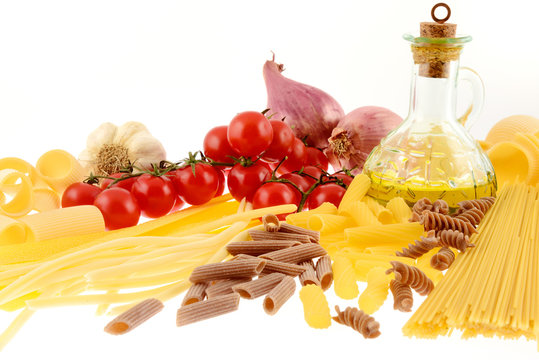 Formati di pasta cruda con pomodorini isolati su sfondo bianco
