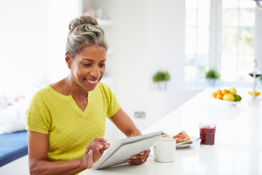 African American Woman Using Digital Tablet At Home