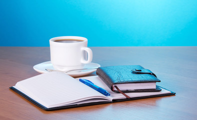 Open notepad and cup of coffee