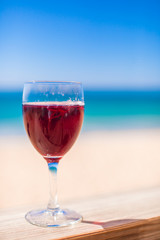 Glass of red wine against the turquoise sea