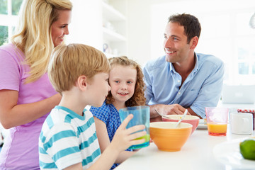 Family Having Breakfast In Kitchen Together