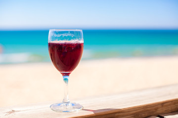 Glass of red wine against the turquoise sea