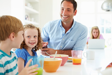 Obraz na płótnie Canvas Family Having Breakfast In Kitchen Together
