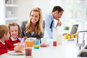 Obraz na płótnie Canvas Family Having Breakfast In Kitchen Before School And Work