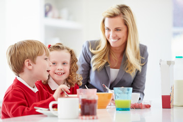 Obraz na płótnie Canvas Mother And Children Having Breakfast In Kitchen Together