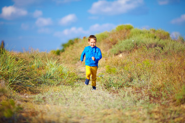 Naklejka na ściany i meble happy kid running the summer field
