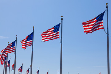 American flags - star and stripes floating over a cloudy blue sk