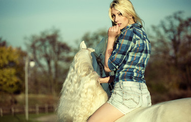 Mystery blonde woman riding a horse
