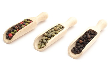Colored, green and black pepper on wooden spoons