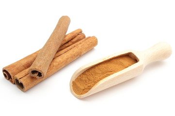 Powdery and stack of cinnamon sticks on white background