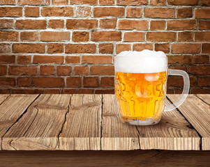 Beer on wooden table with brick background