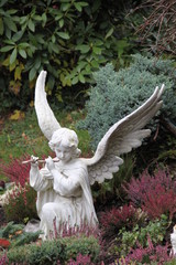 Engel spielt Flöte auf dem Friedhof