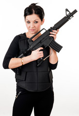 Fototapeta na wymiar Young girl with black gun and paintball equipment