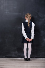schoolgirl leaning her forehead against blackboard