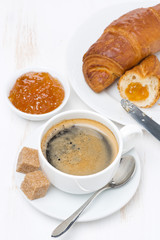 fresh breakfast with black coffee, croissants and orange jam