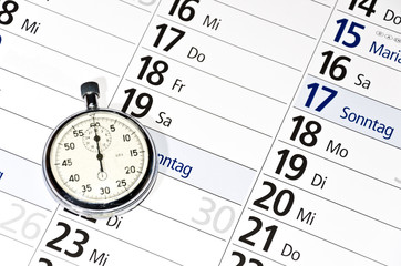 Stoppuhr auf Kalender als Symbol für Zeitmanagement