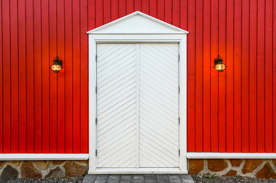 Red wooden wall and white doors with two lamps