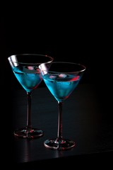 glasses of fresh blue cocktail with ice on bar table