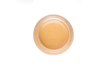 Mustard in a small glass jar isolated on white background
