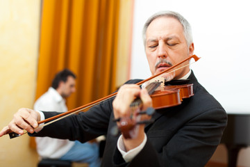 Man playing violin with a pianist