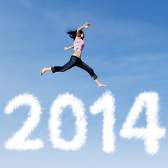 Woman jumping with new year 2014 of clouds