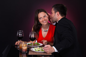 Man Telling Secret To Woman