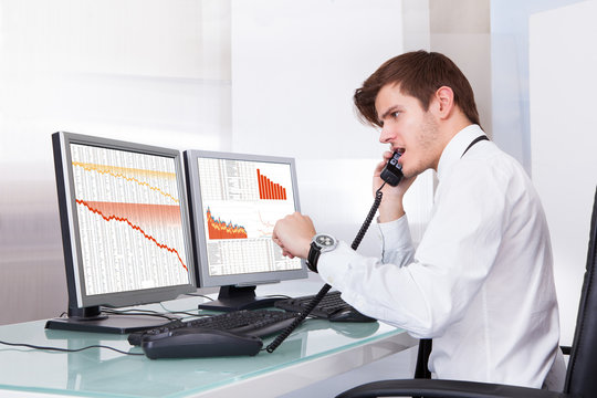 Frustrated Stock Broker Working At Office