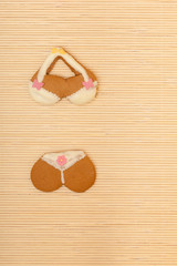 Yellow pink bikini shape gingerbread cake cookie on bamboo mat
