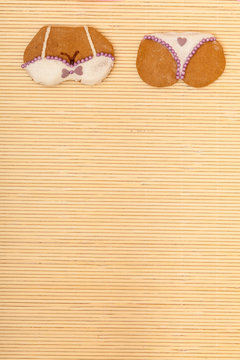 Yellow pink bikini shape gingerbread cake cookie on bamboo mat