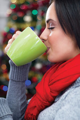 women in Christmas night drinking hot tea, in the background Chr