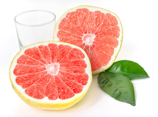 Fresh, ripe, organic grapefruit with glass and leaves.