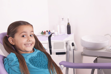 pretty little girl in dentist chair waiting for doctor