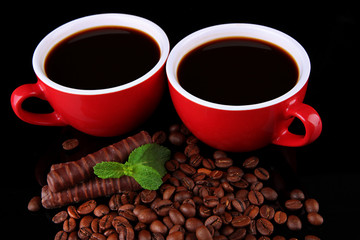 Red cups of strong coffee with coffee beans and chocolate bars