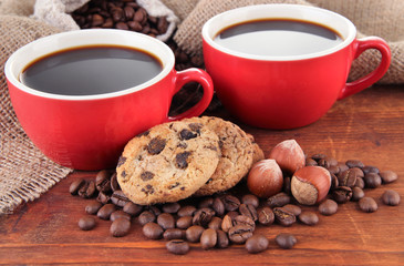 Red cups of strong coffee with coffee beans and cookies