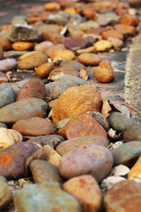 Brown stones laid on a cement floor.