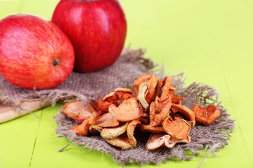 Dried apples, on cutting board,  on color wooden background