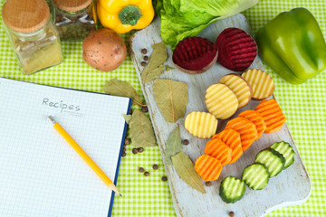 Beautiful sliced vegetables, on plate, on wooden background
