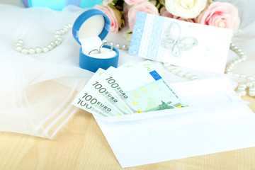 Euro banknotes as gift at wedding on wooden table close-up