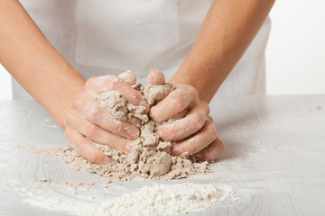 hands knead rye dough