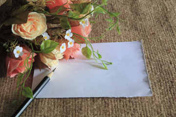 flower laying on brown canvas with blank paper