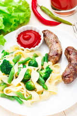 Fettuccine with vegetables and fried sausages