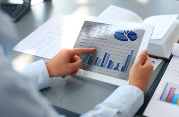 person analyzing statistics displayed on the tablet