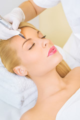Obraz na płótnie Canvas Cosmetologist applying permanent make up on eyebrows