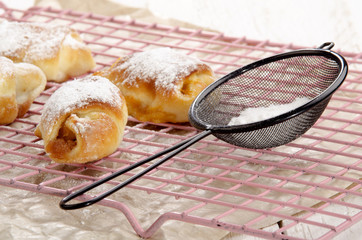 croissant with powdered sugar on a kitchen rack