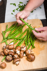Cook cutting green beans in kitchen