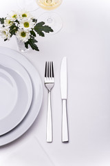 Restaurant table set with white flowers
