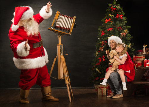 Santa Claus taking picture of family - cheerful woman with her d